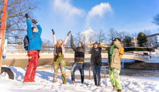 Opiskelijat heittelevät lunta Aurajoen rannassa.
