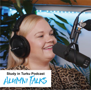 Nainen kuulokkeet päässä mikrofonin äärellä