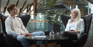 Nuori mies ja nainen juttelevat pöydän ääressä.